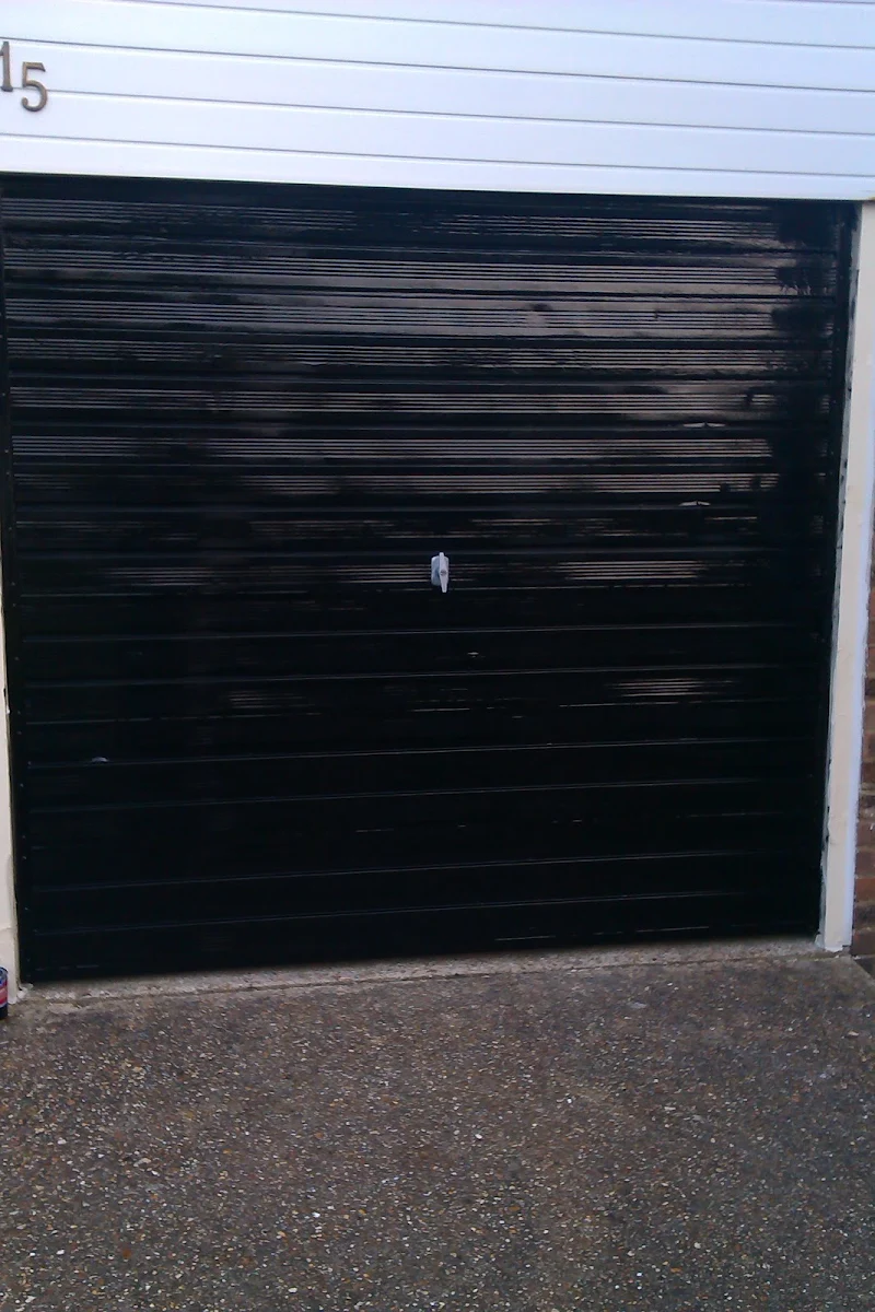 Same garage door freshly repainted in solid black by J.S Painting Contractors