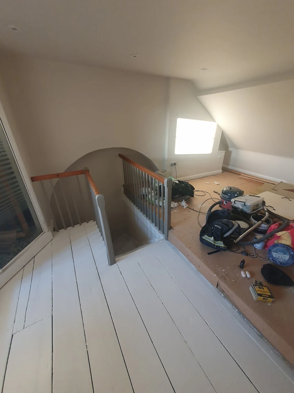 Loft conversion floor and staircase mid-decoration with tools laid out